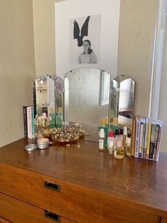 a dresser with several items on it and a mirror in the corner next to it