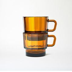 two yellow cups stacked on top of each other in front of a white background,