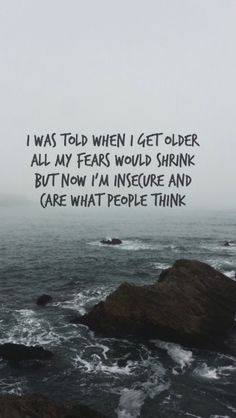 an ocean with rocks and the words i was told when i get older all my fears would shrink but now i'm inse