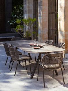 an outdoor dining table and chairs in the shade