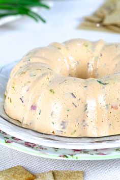 a bundt cake sitting on top of a plate next to crackers