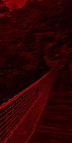 a tennis net with trees in the background and red light coming from it's top