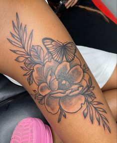 a woman's thigh with flowers and butterflies on it