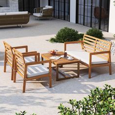 an outdoor patio with wooden furniture and white cushions