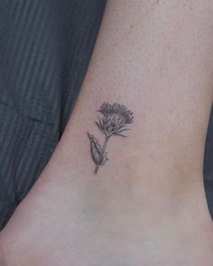 a small flower tattoo on the ankle