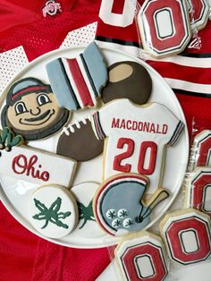 decorated cookies on a plate with the number 20 and football jersey in the background, along with other sports related items