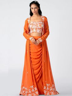 A three-piece orange floral embroidered jacket set from the Suruchi Parakh collection. The hand-embroidered top is paired with matching draped cowl skirt with a slit. The top has floral print all over along with padding. The orange color with threadwork and sequins enhance the graceful jacket set in georgette crepe fabric. The outfit is completed with an embroidered jacket. Cowl Skirt, Crop Top Sleeveless, Embroidered Motifs, Padded Blouse, Draped Skirt, Floral Jacket, Indian Fashion Designers, Long Jacket, Embroidered Jacket