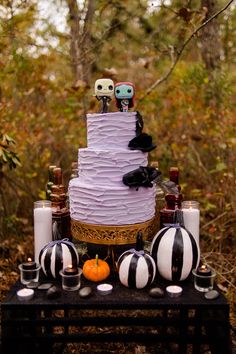 a three tiered cake sitting on top of a table surrounded by candles and decorations