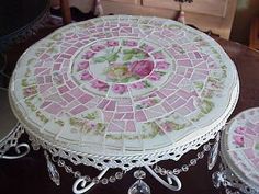 two pink and white mosaic tables with roses on them, one is sitting next to the other