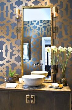 a bathroom vanity with a large mirror and bowl on the counter next to vases