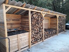 a building made out of wood with logs stacked on top of each other in front of it