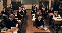 a group of young men sitting at desks in a classroom