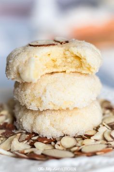 three cookies stacked on top of each other with almonds in the bottom and one half eaten