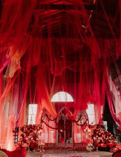 an elaborately decorated room with red sheer curtains