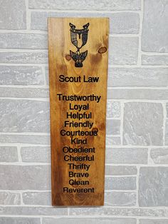 a wooden plaque with the words scout law on it