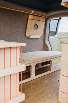 the inside of a camper van with wood shelves and storage compartments on each side