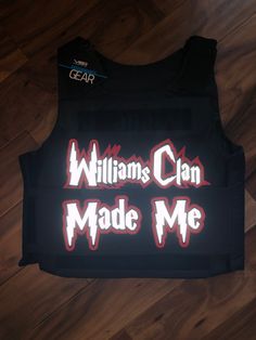 a black vest with the words william's clan made me printed on it, sitting on a wooden floor