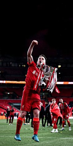 the soccer player is celebrating his team's victory on the field with their trophy