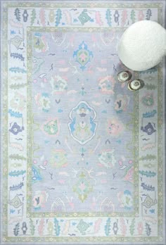 a blue rug with an ornate design on the bottom and a white pom pom