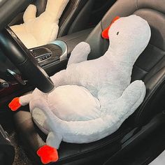 a stuffed animal sitting in the driver's seat of a car with steering wheel