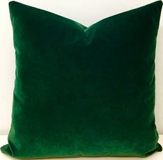 a green pillow sitting on top of a white couch