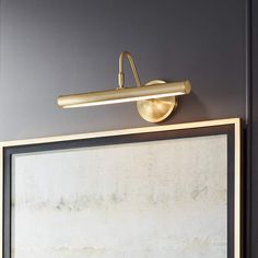 a bathroom light that is next to a painting on the wall in front of it