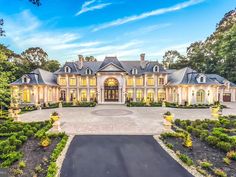 a large house with lots of trees and bushes in front of the entrance to it