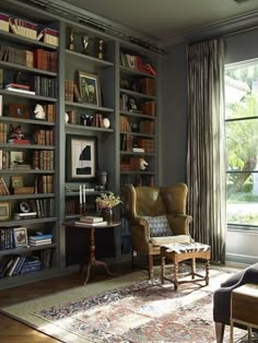 a living room filled with lots of furniture and bookshelves next to a window