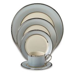 a stack of plates and cups with saucers