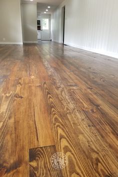 an empty room with hard wood floors and white walls in the background, is shown