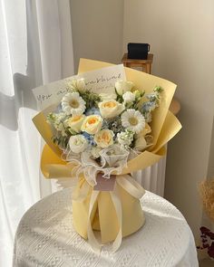 a bouquet of flowers sitting on top of a table next to a teddy bear and card