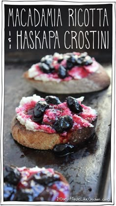 three bagels with blueberries and cream cheese on them sitting on a baking sheet