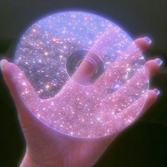 a person holding up a pink disc with stars on it