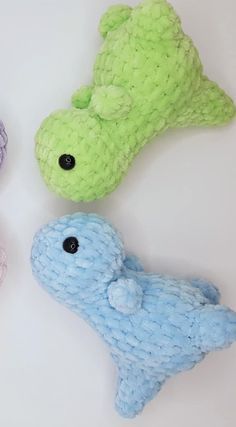 four different colored stuffed animals sitting on top of a white table next to each other