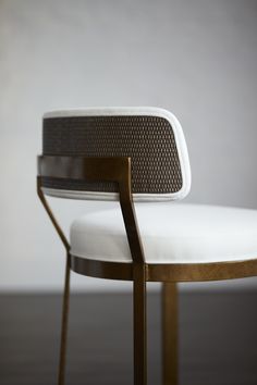 a white chair sitting on top of a hard wood floor next to a gray wall