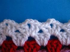 crocheted red and white stitchs are arranged in rows on a blue surface