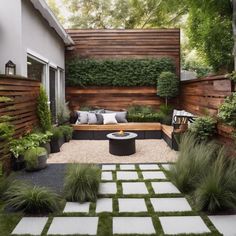 an outdoor seating area with green grass and white stepping stones, surrounded by wooden slatted walls