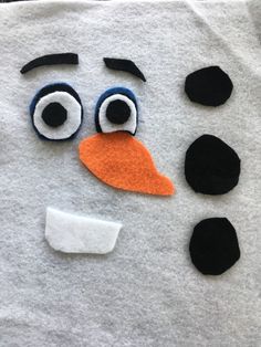 a close up of a snowman made out of felt with googly eyes and nose