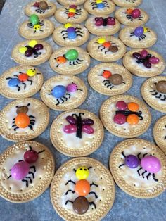 cookies decorated with candy bugs and spider webs are arranged in rows on the floor