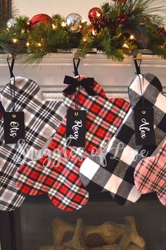 christmas stockings hanging from a mantel decorated with plaid and monogrammed stocking