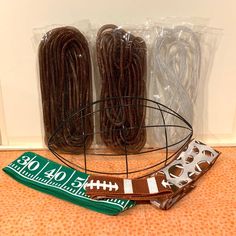 two football bracelets, one in brown and one in green are sitting on the floor