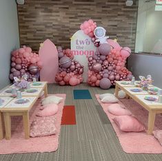 two tables with pink and purple balloons on them in front of a sign that says i love you