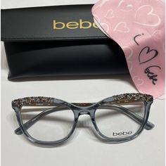 a pair of glasses sitting on top of a table next to a black case and pink scarf