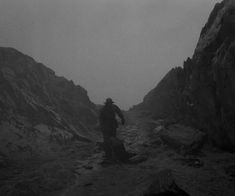 a man walking up a mountain in the rain