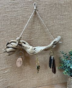 there is a driftwood piece hanging on the wall with key chains attached to it