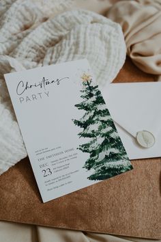 a christmas party card with a tree on it next to an envelope and some other items