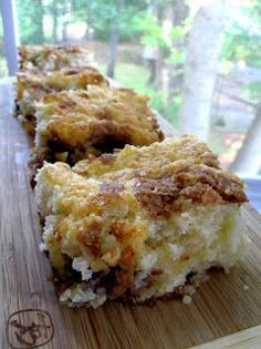 two pieces of cake sitting on top of a wooden cutting board next to a window