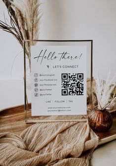 a sign that is on top of a wooden tray next to some dried plants and a potted plant