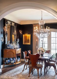 a formal dining room with chandelier, table and chairs