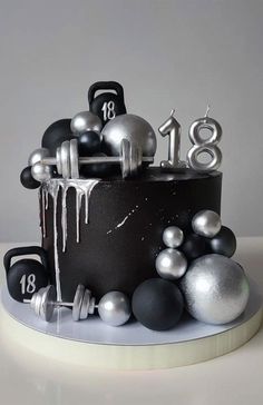 a birthday cake decorated with silver and black decorations